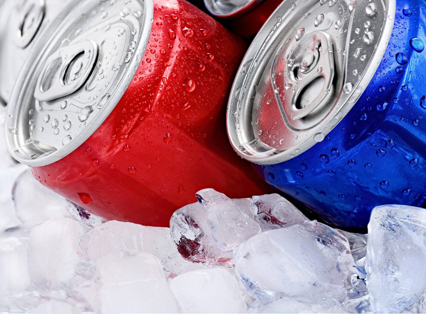 Cans of drink on crushed ice. Red and blue cans with droplets close-up macro